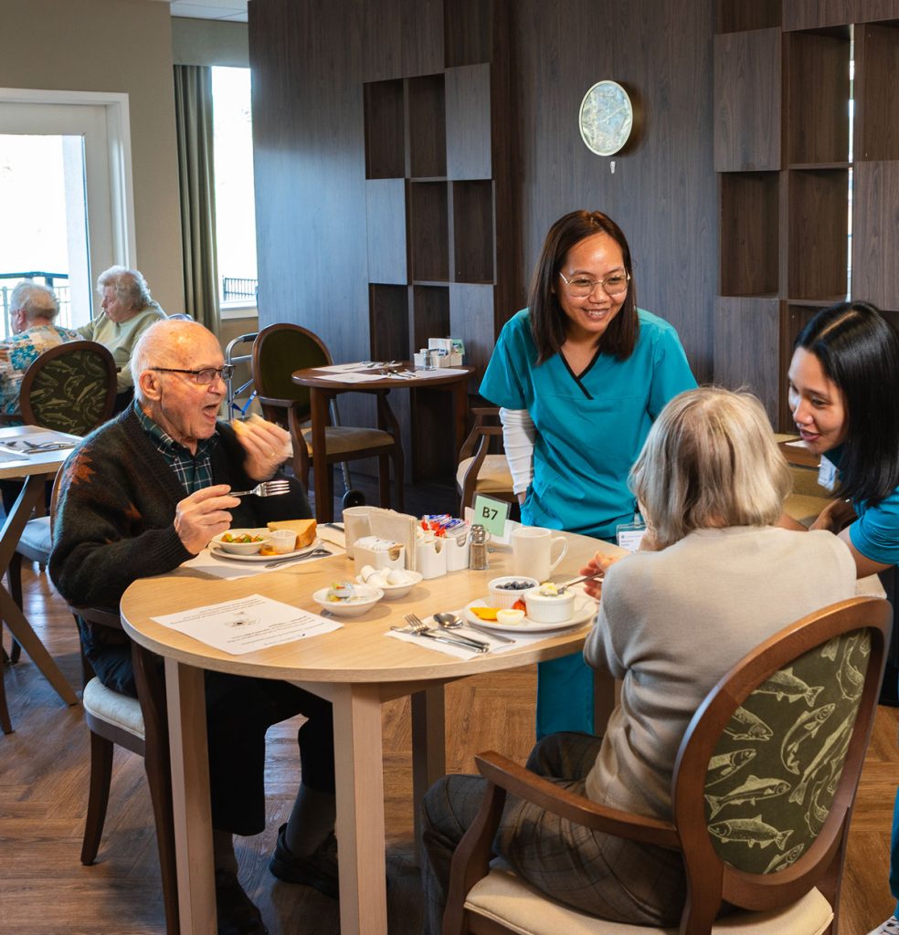 team members serving residents in dining room