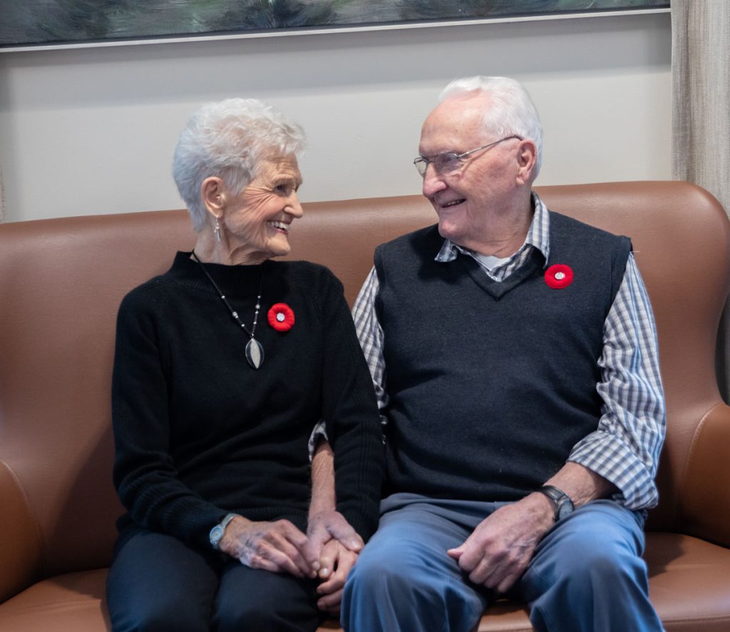 two smiling residents holding hands